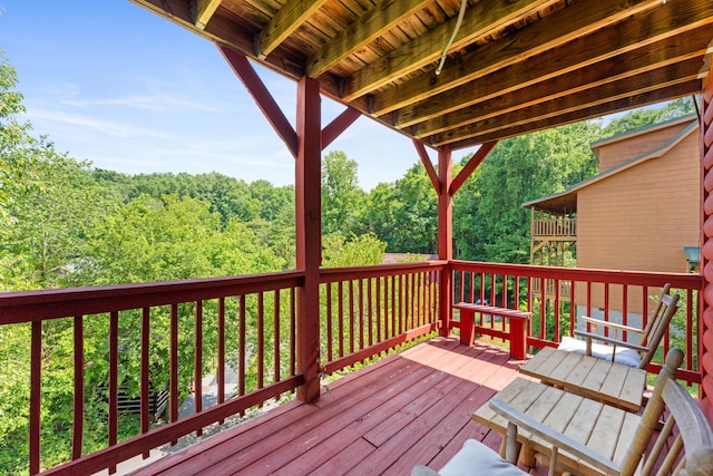 wooden terrace featuring a view of trees