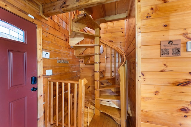 staircase featuring wooden ceiling and wooden walls