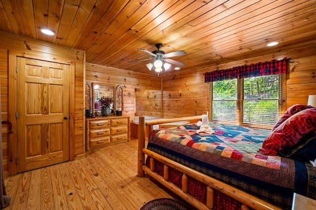 bedroom featuring wood ceiling, light hardwood / wood-style flooring, ceiling fan, and wood walls