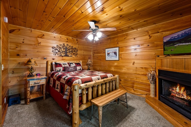 bedroom with dark colored carpet, ceiling fan, and wood ceiling