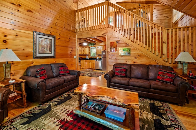 living room with high vaulted ceiling and light hardwood / wood-style flooring