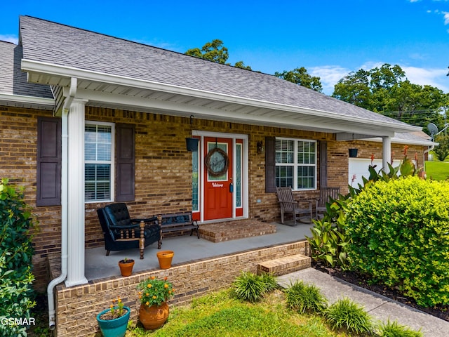 923 Red Oak Ln, Dandridge, TN 37725 - view of exterior entry featuring a porch, brick siding, and a shingled roof
