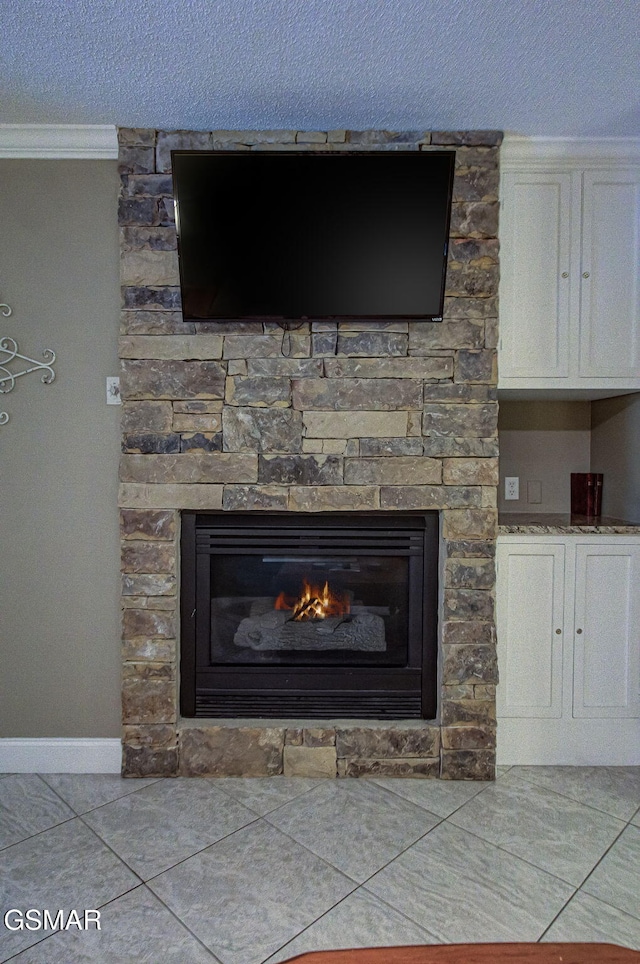 3215 N River Rd Unit 103, Pigeon Forge, TN 37863 - detailed view of crown molding, a stone fireplace, a textured ceiling, and baseboards