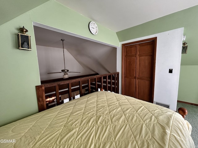 carpeted bedroom with ceiling fan, lofted ceiling, and a closet