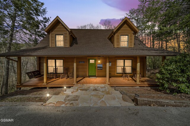 view of front of home with roof with shingles and faux log siding