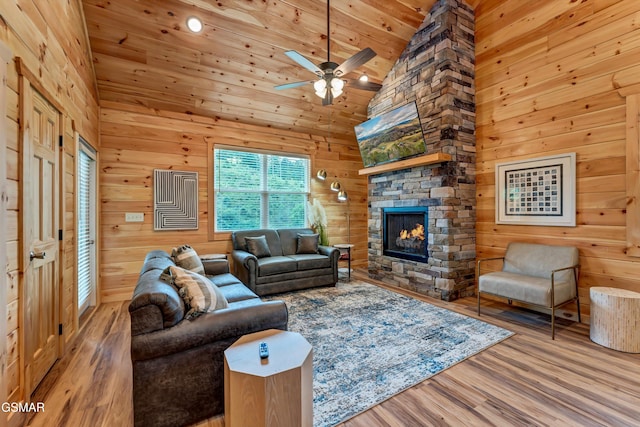 1014 Pinyon Cir, Pigeon Forge, TN 37863 - living area featuring wood finished floors, a fireplace, ceiling fan, wood walls, and high vaulted ceiling