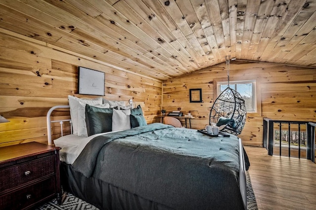 bedroom with wooden walls, wooden ceiling, vaulted ceiling, and light wood-type flooring