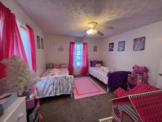 bedroom with ceiling fan, dark carpet, and a textured ceiling