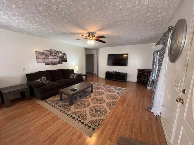 living room with wood-type flooring, a textured ceiling, and ceiling fan