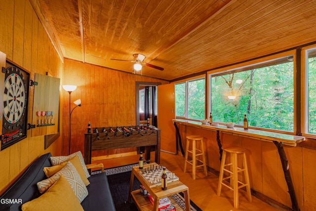 living room with wooden walls, a wealth of natural light, and wooden ceiling