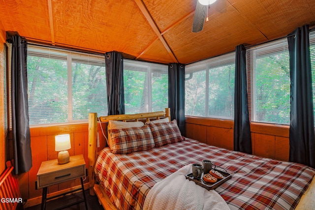 bedroom featuring wood ceiling, wooden walls, and multiple windows