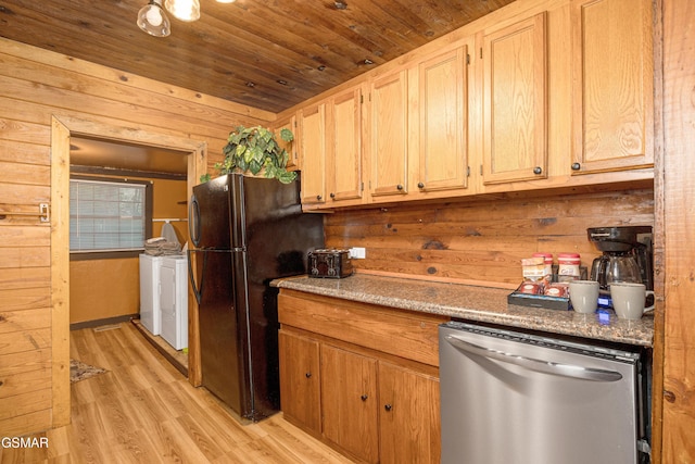 kitchen featuring light brown cabinetry, stainless steel dishwasher, washer and clothes dryer, light hardwood / wood-style flooring, and wood walls