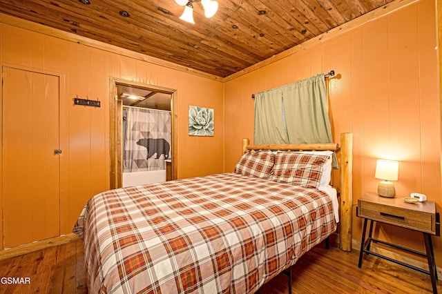 bedroom with wooden walls, hardwood / wood-style flooring, and wooden ceiling