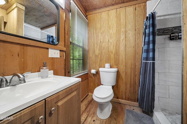 215 Lovers Ln, Townsend, TN 37882 - bathroom with tiled shower, toilet, vanity, wood finished floors, and wooden walls