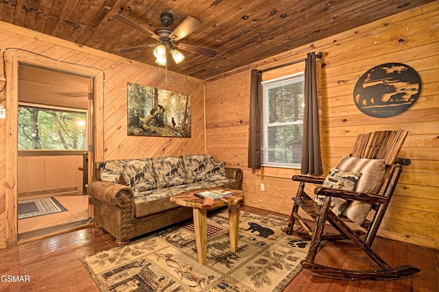 living room featuring wooden walls, hardwood / wood-style floors, ceiling fan, and wood ceiling