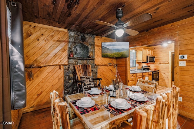 dining room featuring ceiling fan, wood walls, wood ceiling, and dark hardwood / wood-style floors