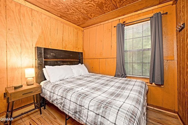 bedroom featuring hardwood / wood-style floors, wood walls, and wooden ceiling