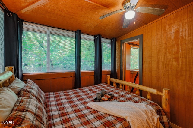 bedroom with ceiling fan, wood ceiling, wooden walls, and vaulted ceiling