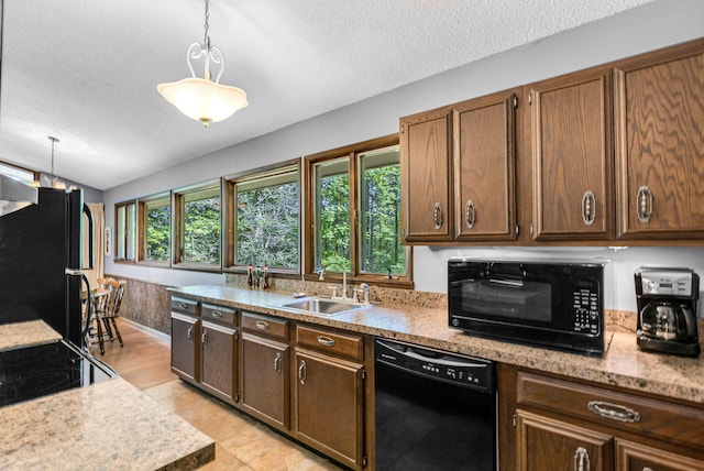 kitchen with black appliances, pendant lighting, sink, and a textured ceiling