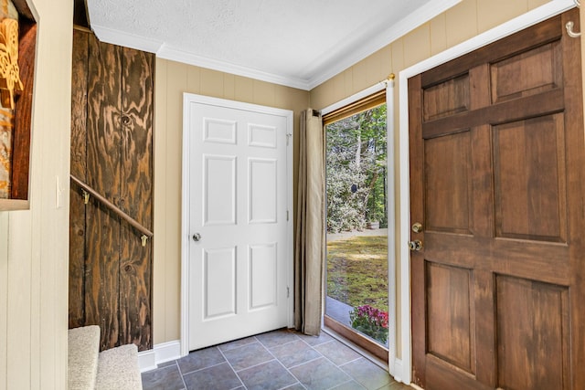 entrance foyer with crown molding, wooden walls, and a textured ceiling