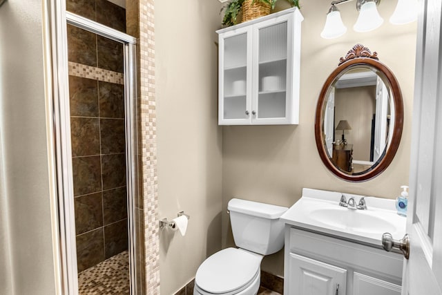 bathroom featuring vanity, toilet, and a shower with door