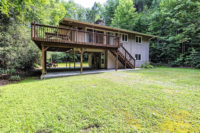 rear view of house featuring a lawn, a deck, and a patio