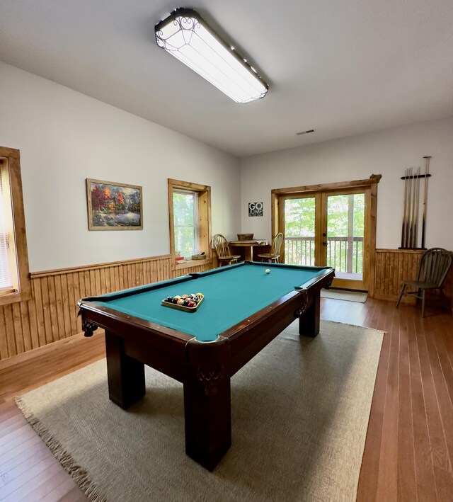 playroom with wooden walls, light wood-type flooring, and pool table