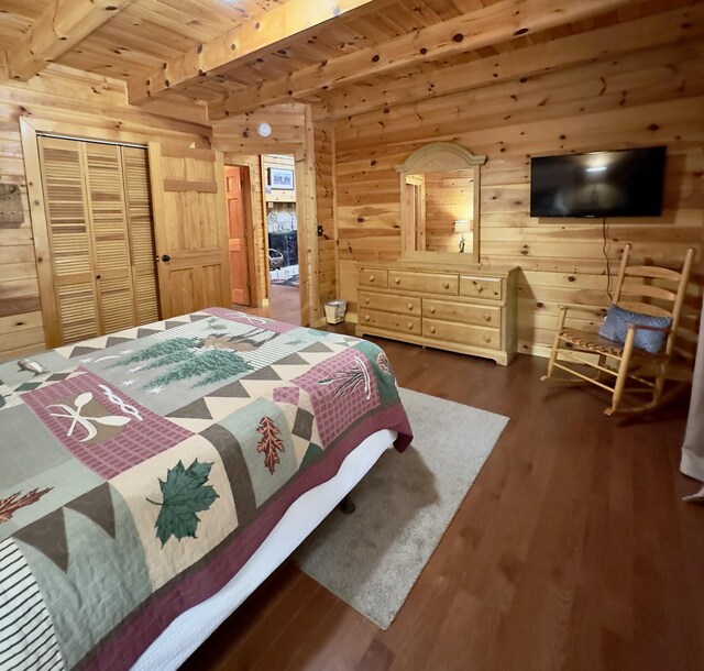 bedroom featuring beam ceiling, wooden ceiling, dark hardwood / wood-style floors, wooden walls, and a closet