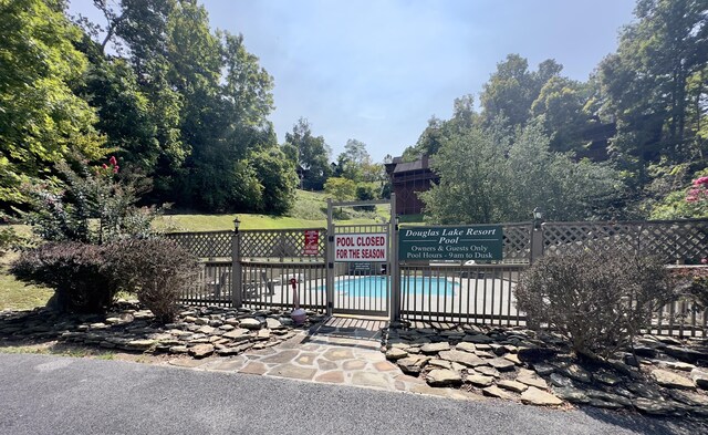 view of gate featuring a community pool