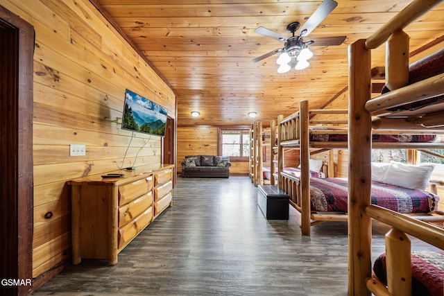 bedroom with lofted ceiling, wooden walls, wooden ceiling, and ceiling fan