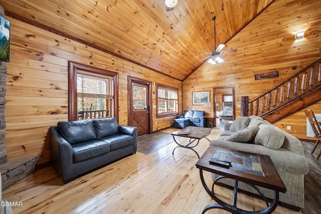 living room with wooden ceiling, wood walls, ceiling fan, and light wood-type flooring