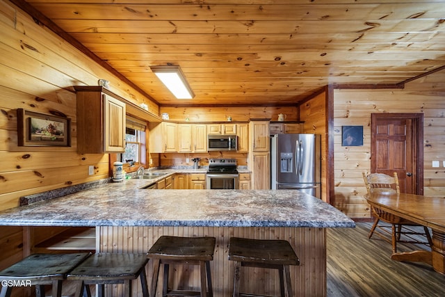 kitchen featuring kitchen peninsula, stainless steel appliances, wooden walls, wood ceiling, and a kitchen breakfast bar