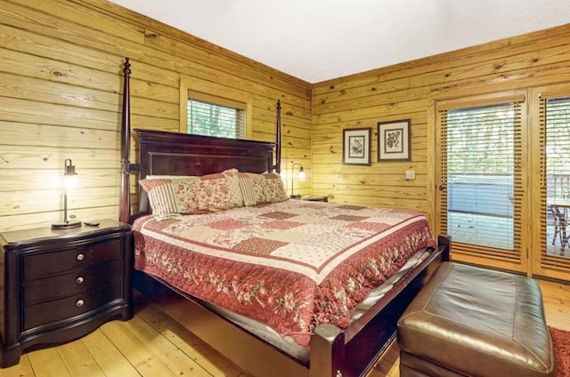 bedroom with light wood-type flooring and wooden walls