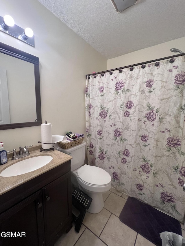 bathroom with toilet, a textured ceiling, a shower with shower curtain, tile patterned flooring, and vanity