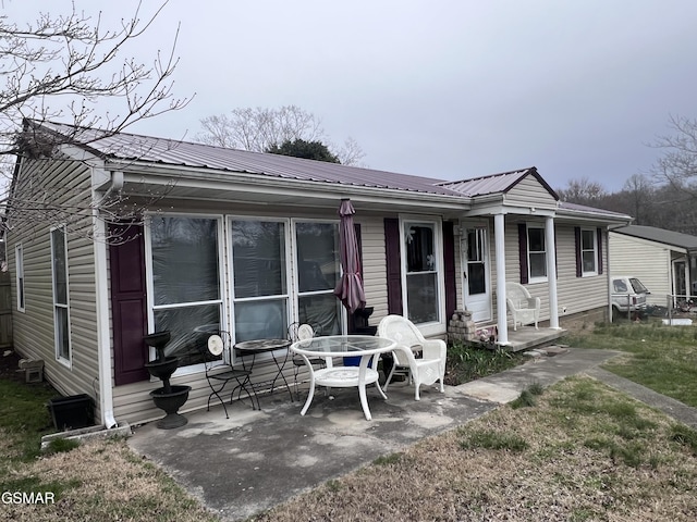 view of front facade featuring a patio area and metal roof