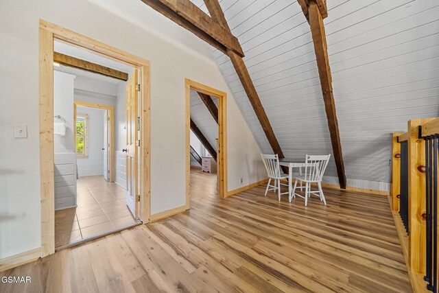 bonus room with light hardwood / wood-style flooring and lofted ceiling with beams