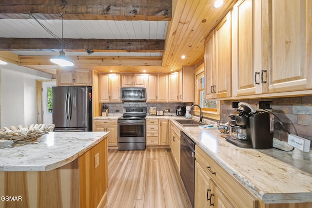 kitchen with appliances with stainless steel finishes, sink, light brown cabinets, pendant lighting, and light hardwood / wood-style floors