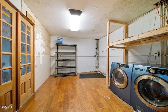 laundry room with washer and clothes dryer and light hardwood / wood-style flooring