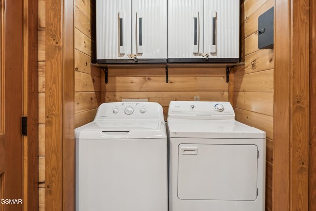2083 Kerr Rd, Sevierville, TN 37876 - clothes washing area with washer and dryer, cabinet space, and wood walls