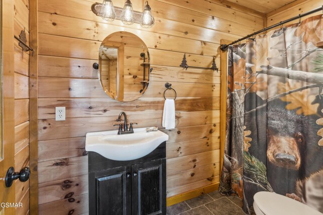 2083 Kerr Rd, Sevierville, TN 37876 - bathroom featuring tile patterned flooring, wooden walls, vanity, toilet, and a shower with curtain