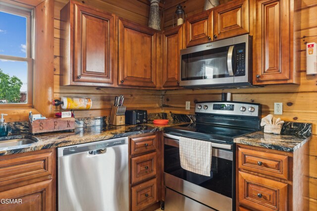2083 Kerr Rd, Sevierville, TN 37876 - kitchen with appliances with stainless steel finishes, brown cabinets, dark stone counters, and a sink
