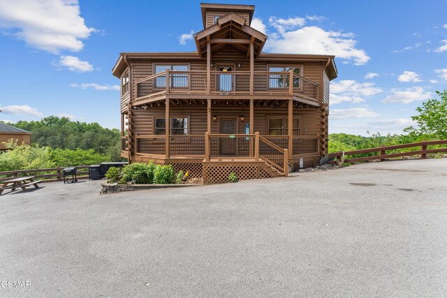 2083 Kerr Rd, Sevierville, TN 37876 - back of house with a balcony, log exterior, and covered porch