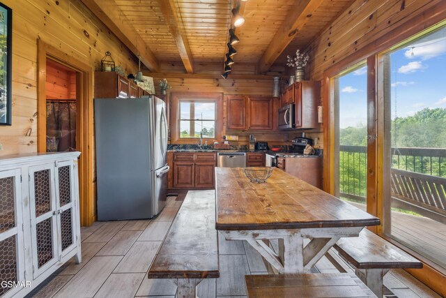 2083 Kerr Rd, Sevierville, TN 37876 - kitchen featuring stainless steel appliances, wooden walls, track lighting, wooden ceiling, and brown cabinets