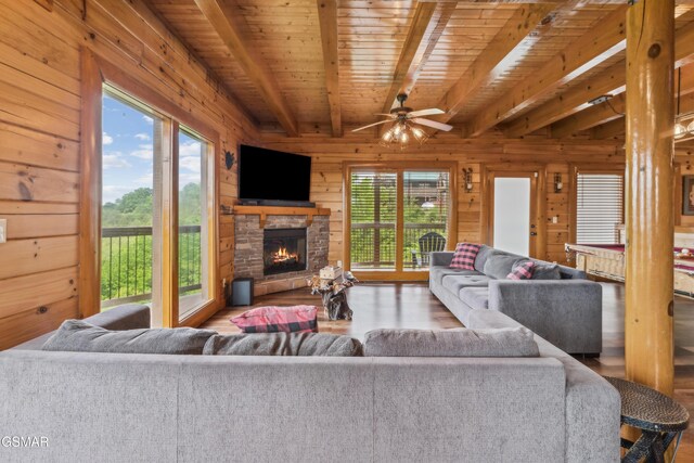 2083 Kerr Rd, Sevierville, TN 37876 - living area featuring beamed ceiling, wooden ceiling, wood walls, healthy amount of natural light, and an outdoor stone fireplace