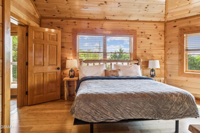 2083 Kerr Rd, Sevierville, TN 37876 - bedroom featuring wooden walls, vaulted ceiling, and light wood-type flooring