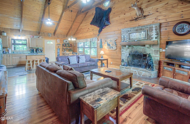 3529 Peggy Ln, Pigeon Forge, TN 37863 - living area with ceiling fan, wood finished floors, a fireplace, wooden walls, and wooden ceiling with exposed beams