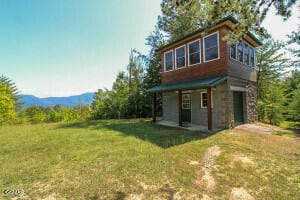 rear view of house featuring a lawn and a mountain view