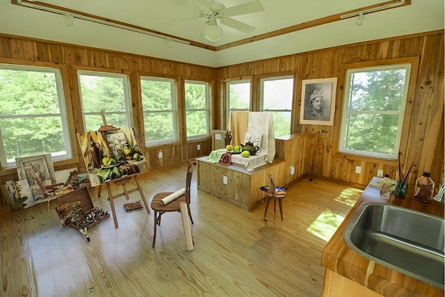 sunroom featuring ceiling fan, a sink, and a wealth of natural light