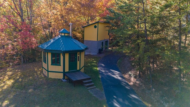 view of outbuilding with an outbuilding and a view of trees