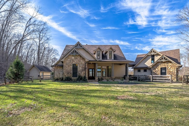 view of front of home featuring stone siding, a porch, a front lawn, and fence